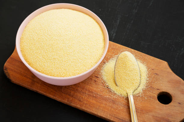 istock Dry semolina durum flour in a pink bowl over black background, side view. Close-up. 1156329607