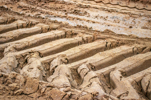 istock excavator tire tracks in the sand; structured background 1156334035