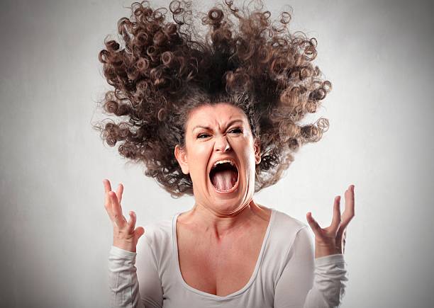 Rage Portrait of a furious woman with hair up in the air shouting stock pictures, royalty-free photos & images