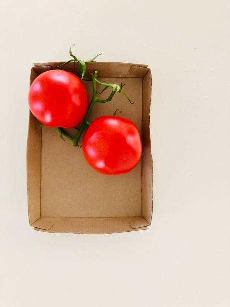 istock Two Red Tomatoes in a Brown Cardboard Box 2 1156338583