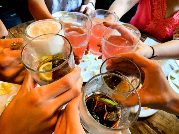 Circle of people holding drinks and making drink