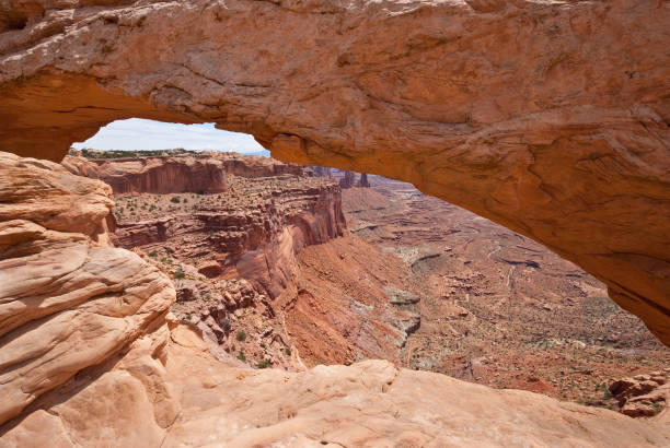 Mesa Arch Mesa Arch is a pothole arch, formed when rainwater eventually broke the bonds between grains of sand and deepened surface depressions into a hole.  This arch is also geologically unusual in that it sits at the top of a canyon wall.  Eventually the same forces of water freezing and thawing will lead to the collapse of this arch.  Mesa Arch is on the eastern edge of the Island in the Sky Mesa in Canyonlands National Park near Moab, Utah, USA. jeff goulden canyonlands national park stock pictures, royalty-free photos & images