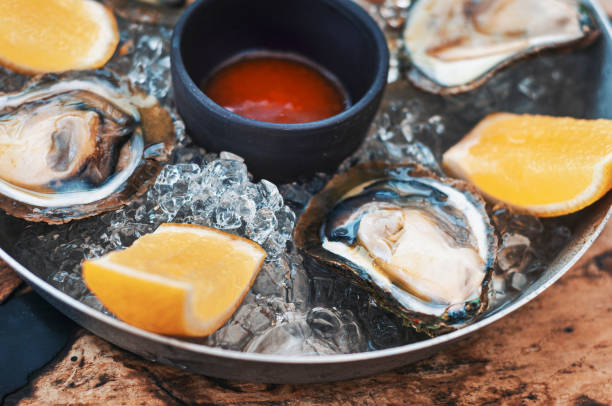 istock Fresh Oysters close-up on metal plate with ice 1156342641