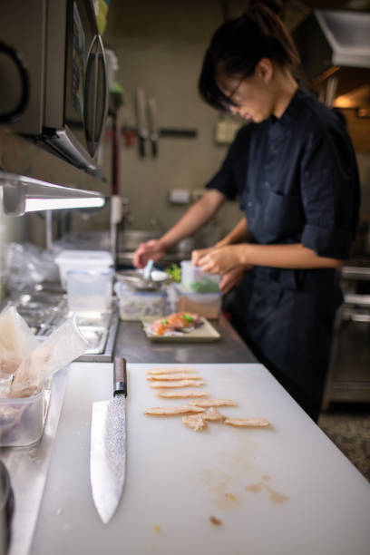 Young female chef preparing salad in kitchen