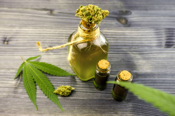 istock Cannabis oils in bottles with Hemp leaf and cannabis buds on wooden table 1156347340