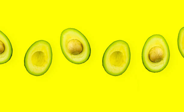 avocado on isolated yellow background. persea americana or avocado shot overhead flat lay - persea imagens e fotografias de stock