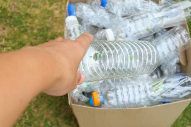 istock Hand hold and put plastic bottles in to brown recycle garbage box 1156350225