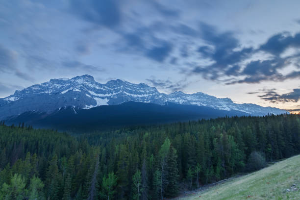 istock Mountains and forest at dusk. Motion blur in clouds 1156351523