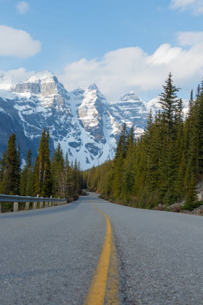 istock Winding Road leading to snow covered mountains 1156351594