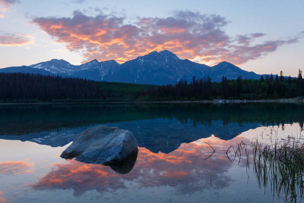 istock Still lake and mountain at sunset, with red clouds 1156351662