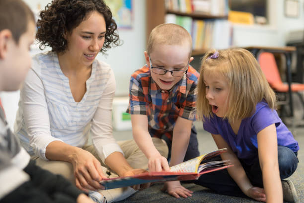istock Female teacher reading to her first grade students 1156352450