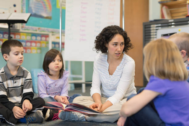 istock Female teacher reading to her first grade students 1156352454