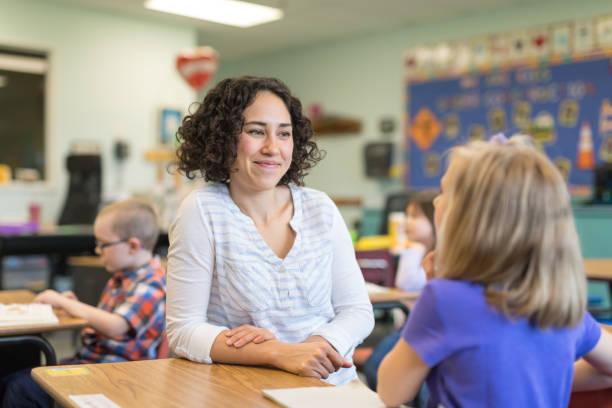 istock A first grade teacher talking with one of her students in the classroom 1156352471
