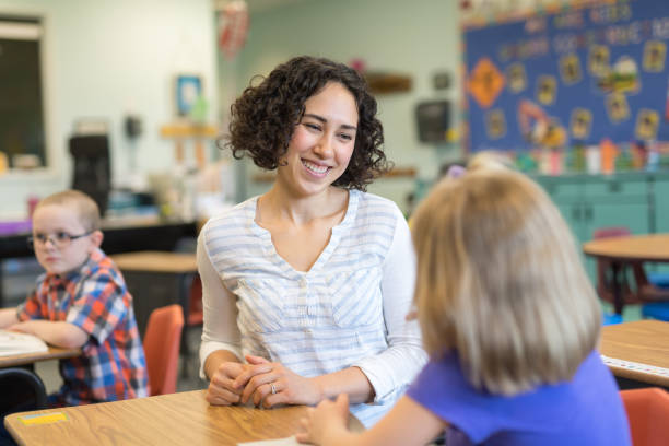 istock A first grade teacher talking with one of her students in the classroom 1156352473