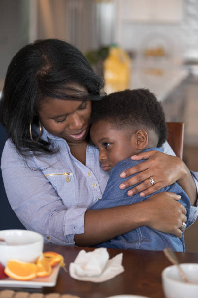 istock Boy sitting in his mom's lap eating breakfast 1156353643