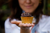 Woman holding tasty chocolate cupcake
