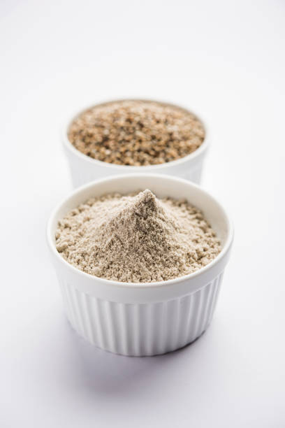 istock Bajra (pearl millet) / sorghum grains with it's flour or powder in a bowl, selective focus 1156358015