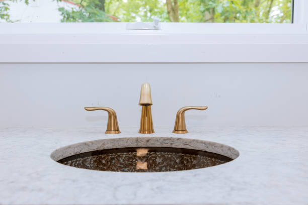 istock Close up of sinks in modern bathroom white stone 1156360263
