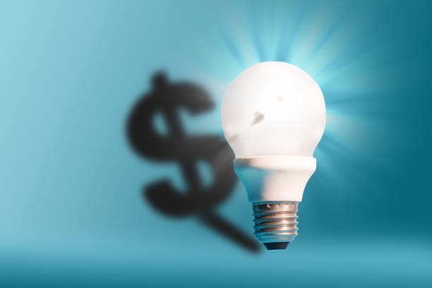 istock Light bulb on bright blue background with a dollar sign shadow. Conception good idea it's money. 1156366940