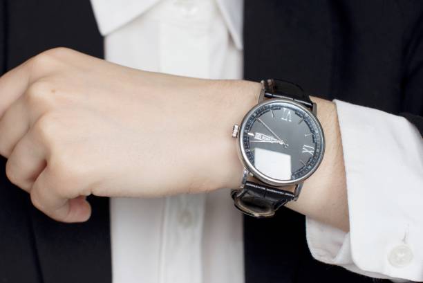 istock young woman in black suit checking time 1156370191
