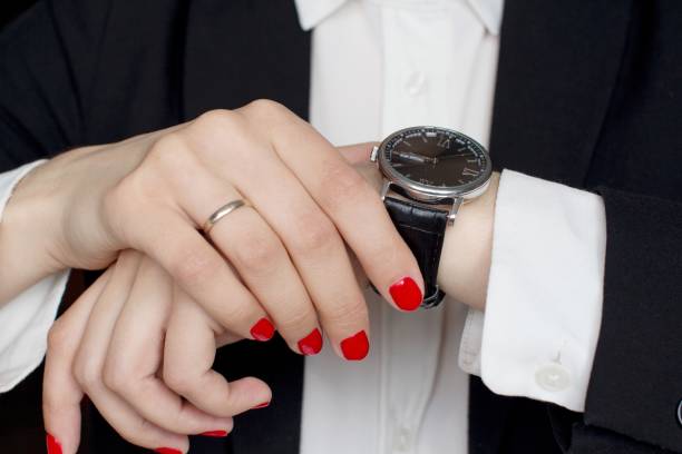 istock young woman in black suit checking time 1156370266