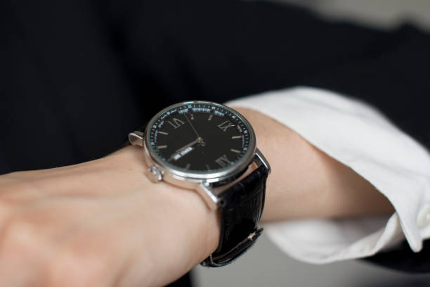 istock young woman in black suit checking time 1156370332