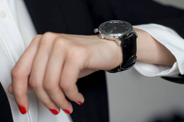 istock young woman in black suit checking time 1156370355