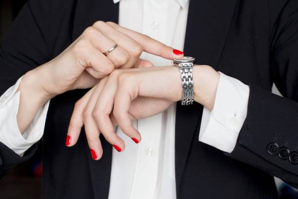 istock young woman in black suit checking time 1156370450