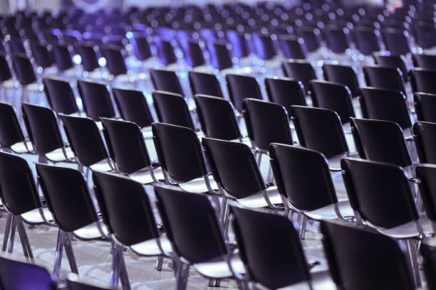 istock Rows of empty plastic seats in an empty conference room. 1156372144
