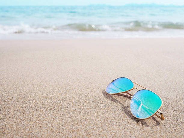 istock sunglasses on sand at beach 1156374057