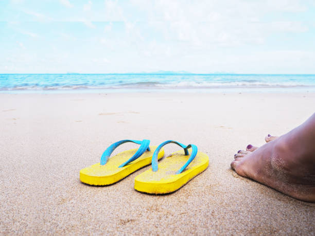 istock selfie barefoot and yellow sandals on the beach. 1156374108