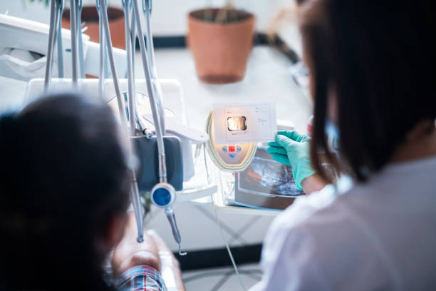 istock Senior dentist looking x-ray with patient. 1156376070