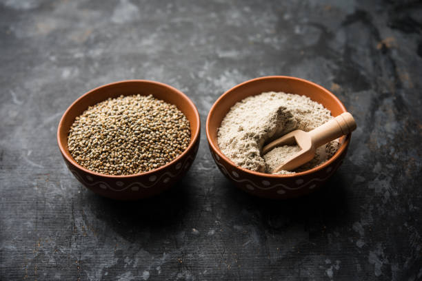 istock Bajra (pearl millet) / sorghum grains with it's flour or powder in a bowl, selective focus 1156377680