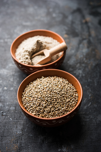 Bajra (mijo perla) / granos de sorgo con su harina o polvo en un tazón, enfoque selectivo photo