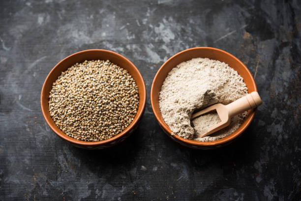 istock Bajra (pearl millet) / sorghum grains with it's flour or powder in a bowl, selective focus 1156378380
