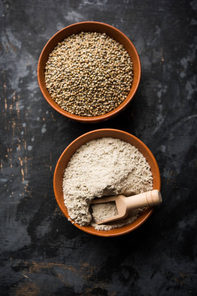 istock Bajra (pearl millet) / sorghum grains with it's flour or powder in a bowl, selective focus 1156378384