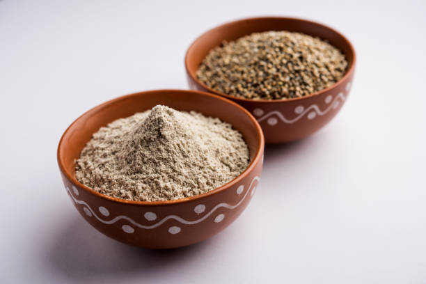 istock Bajra (pearl millet) / sorghum grains with it's flour or powder in a bowl, selective focus 1156378696