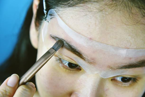 istock Eyebrows shaping makeup template, Asian women filling eyebrows to look thicker, Learning doing self makeup. 1156380923