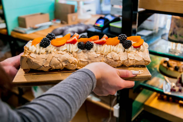 istock salesman in a confectionery holding a meringue cake 1156384749