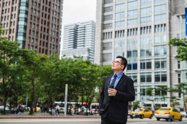 istock Asian Businessman With Coffee Outdoors in Taipei 1156392877