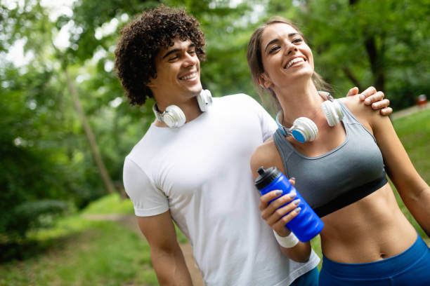 istock Athletic couple friend drinking water after running 1156393558