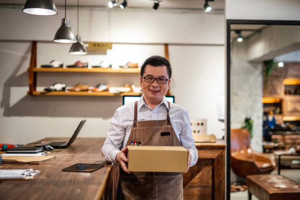 istock Successful Male Taiwanese Shoe Merchant With Shoe Box 1156393602