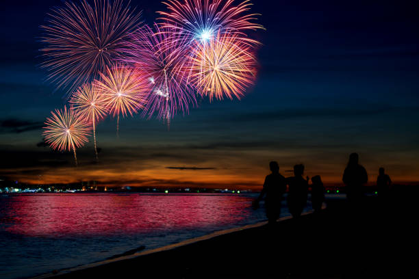 istock Silhouette people looking beautiful fireworks display on the beach ,celebration new year night concept 1156396055