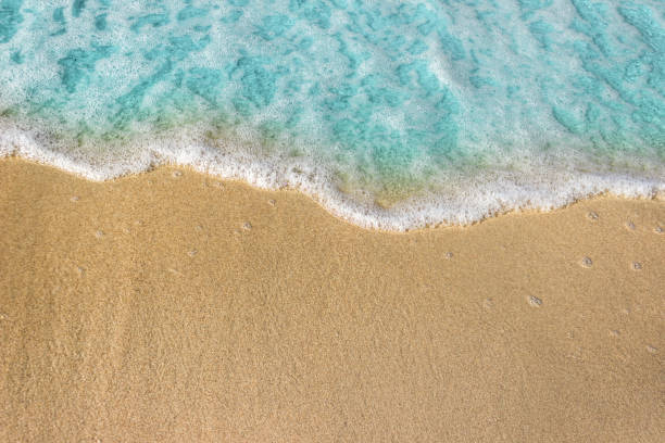 istock Soft blue waves with foam of ocean on the sandy beach background. 1156397470