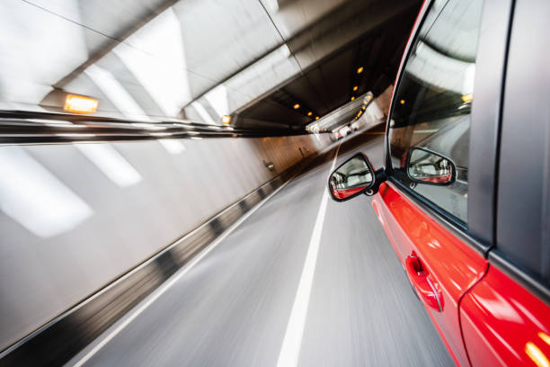 istock Abstract futuristic background. Bright red car in a grey tunnel. 1156399473
