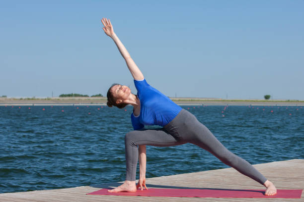 istock Pretty woman practicing yoga at a lake 1156401871