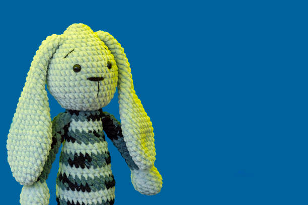 istock Bunny knitted toy on a blue background 1156404617