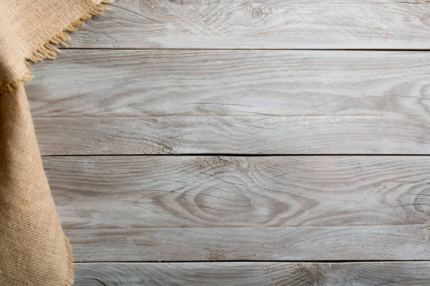 istock Burlap hessian sacking cloth on wooden table background with free space. 1156409421