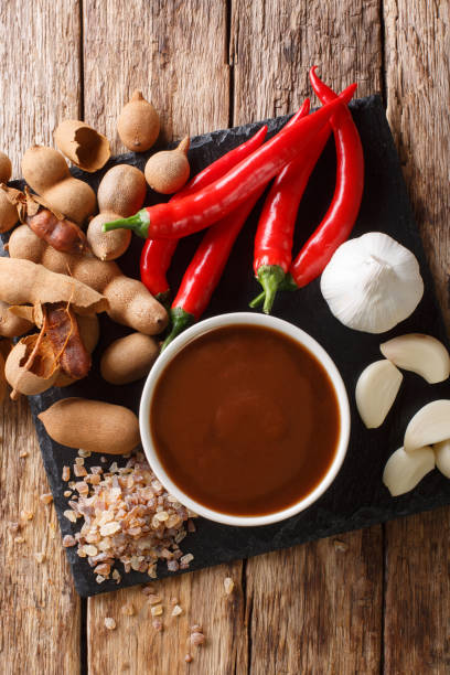 istock Asian freshly prepared tamarind sauce with ingredients close-up on a table. Vertical top view 1156415534