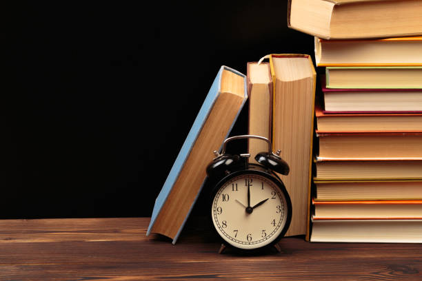 istock Vintage books and clock on wooden table - Image 1156415772